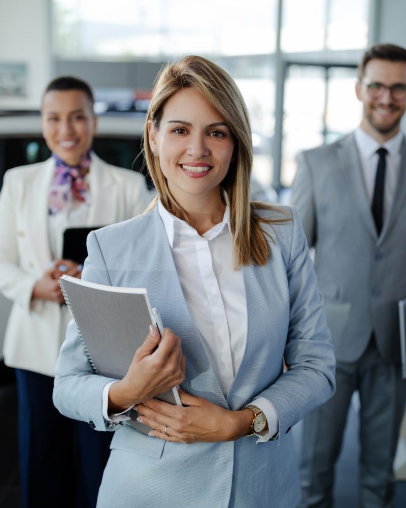 salesteam-in-dealership-three-beautiful-consultants-or-managers-in-elegant-suit-looking-on-camera-.jpg